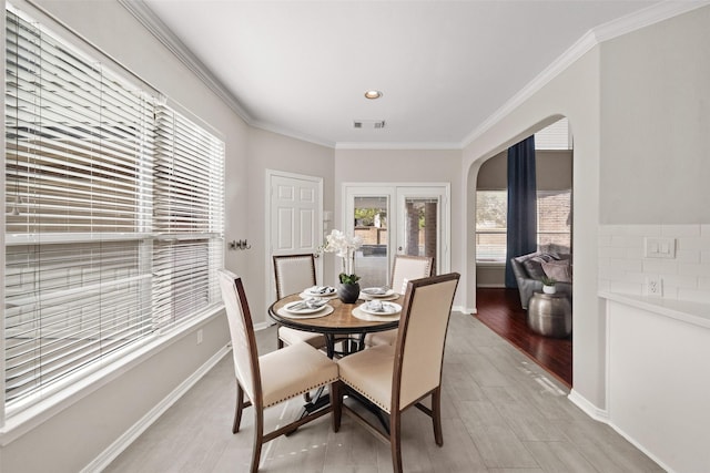 dining space featuring light hardwood / wood-style flooring and ornamental molding