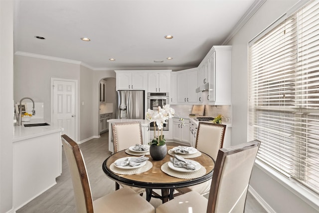 dining room featuring sink and crown molding