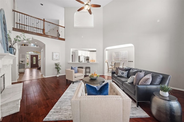 living room featuring dark wood-type flooring and ceiling fan