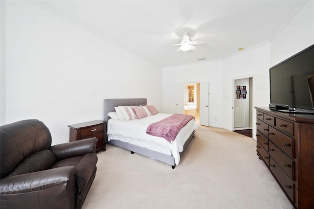 carpeted bedroom with ensuite bath, ornamental molding, and ceiling fan