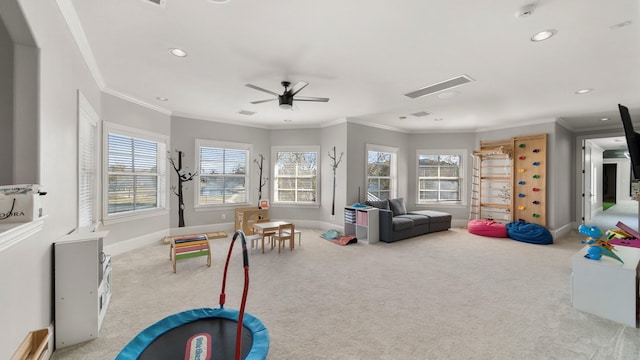 rec room featuring ceiling fan, crown molding, and light colored carpet