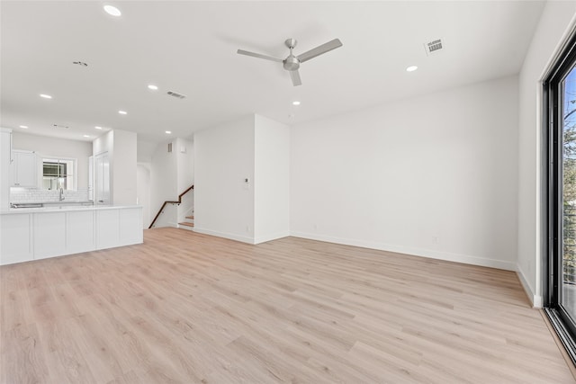 unfurnished living room featuring ceiling fan and light hardwood / wood-style flooring