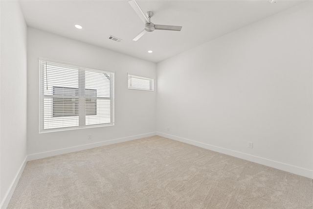 carpeted spare room featuring a wealth of natural light and ceiling fan