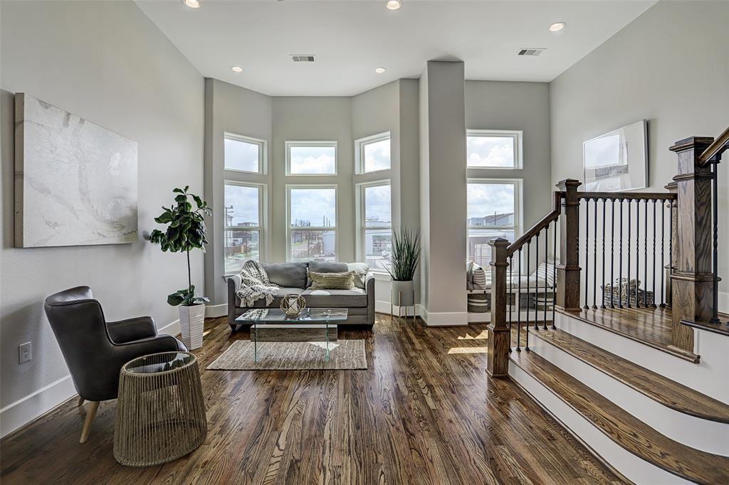 sitting room with a towering ceiling and dark hardwood / wood-style floors