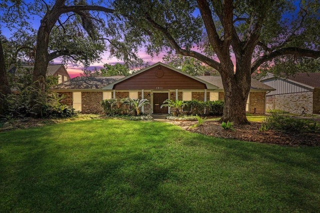 ranch-style home featuring a lawn