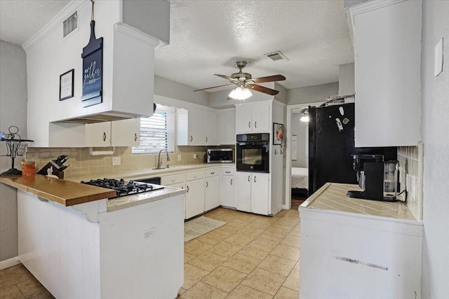 kitchen featuring white cabinetry, kitchen peninsula, a textured ceiling, decorative backsplash, and black appliances