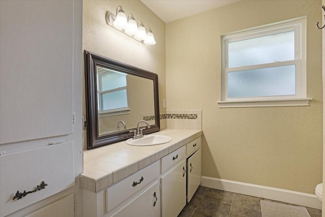 bathroom featuring tile patterned floors, vanity, toilet, and a wealth of natural light