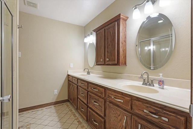 bathroom with tile patterned flooring, vanity, and a shower with door