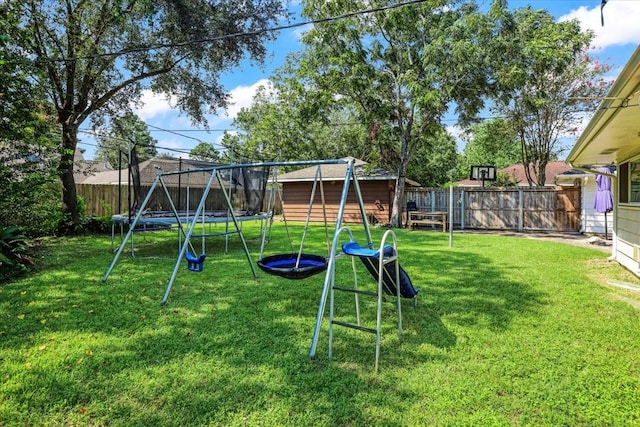 view of playground with a lawn and a trampoline