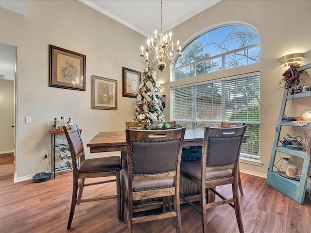 dining space with hardwood / wood-style floors, an inviting chandelier, and ornamental molding