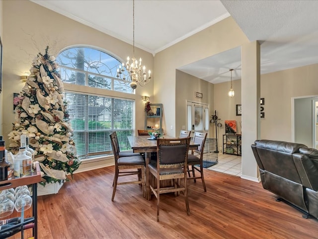 dining room featuring wood-type flooring, an inviting chandelier, and crown molding