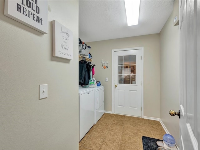 laundry area with independent washer and dryer and a textured ceiling