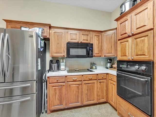 kitchen with tile countertops, decorative backsplash, and black appliances