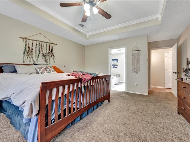 bedroom with ceiling fan, crown molding, connected bathroom, and a tray ceiling