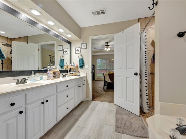 bathroom featuring ceiling fan, walk in shower, and vanity