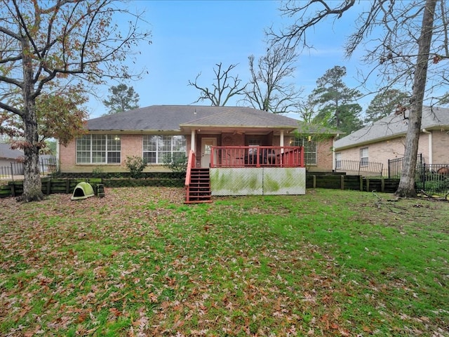 back of house with a deck and a yard