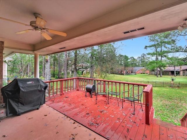 wooden deck featuring a yard, ceiling fan, and a grill