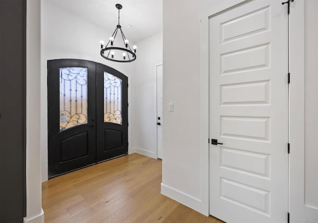 entrance foyer featuring a chandelier, french doors, and hardwood / wood-style flooring