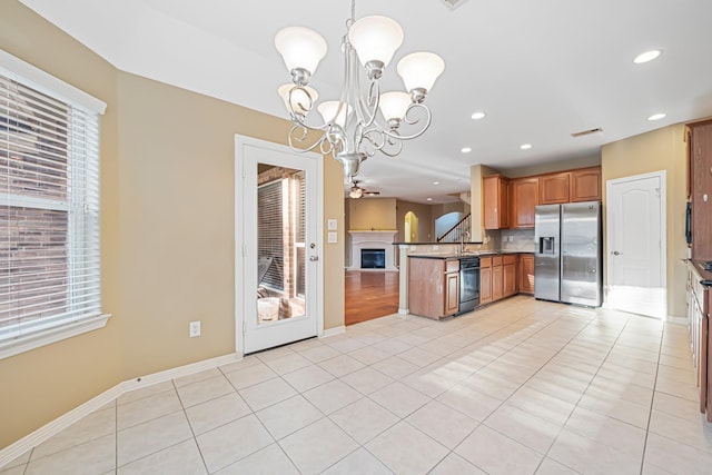 kitchen featuring dishwasher, kitchen peninsula, stainless steel fridge, decorative light fixtures, and light tile patterned flooring