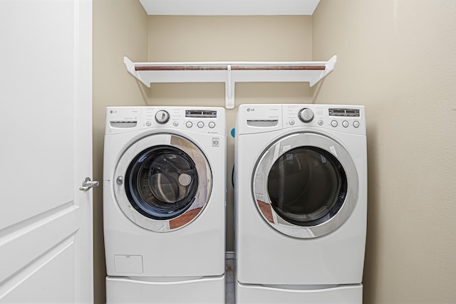 clothes washing area with washing machine and clothes dryer