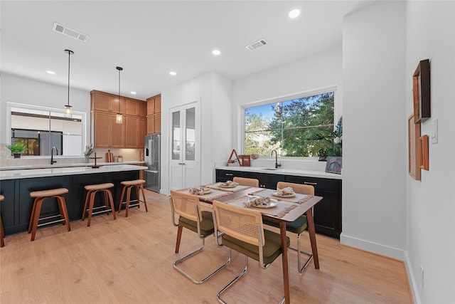 dining room featuring light wood-type flooring and sink