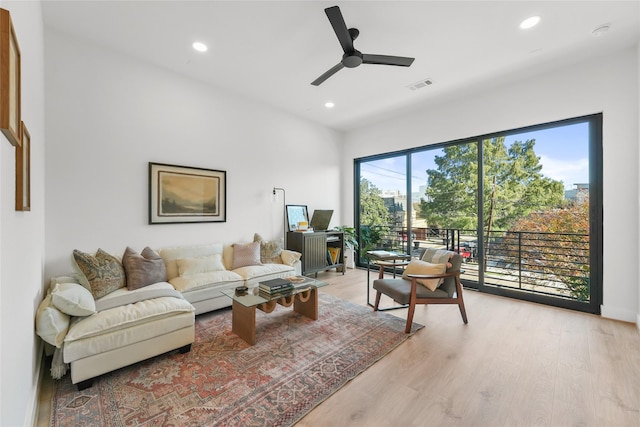 living room with light hardwood / wood-style flooring and ceiling fan