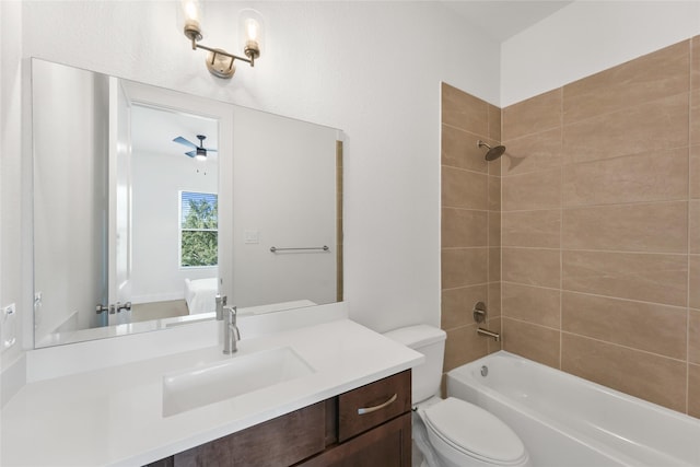 full bathroom featuring ceiling fan, toilet, tiled shower / bath, and vanity