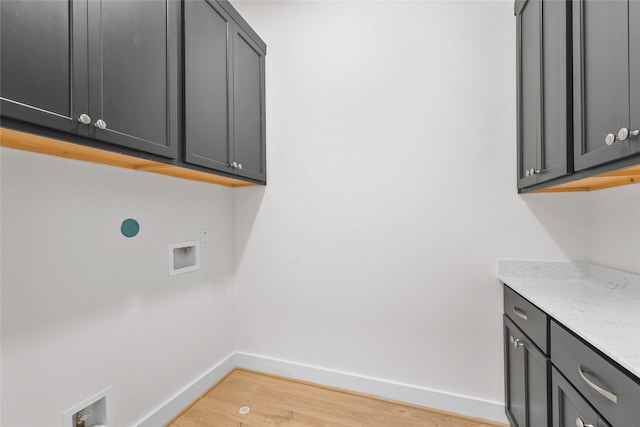 clothes washing area with light hardwood / wood-style floors, cabinets, and hookup for a washing machine