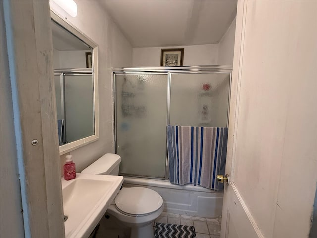 full bathroom with sink, tile patterned floors, combined bath / shower with glass door, and toilet