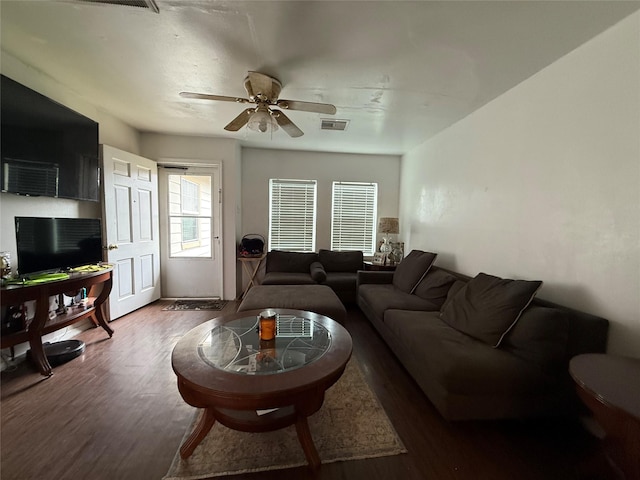 living room featuring ceiling fan and dark wood-type flooring