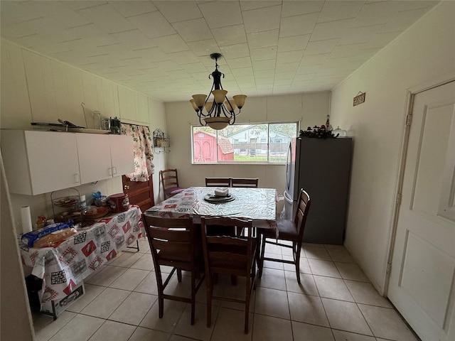 dining space featuring light tile patterned floors and a notable chandelier