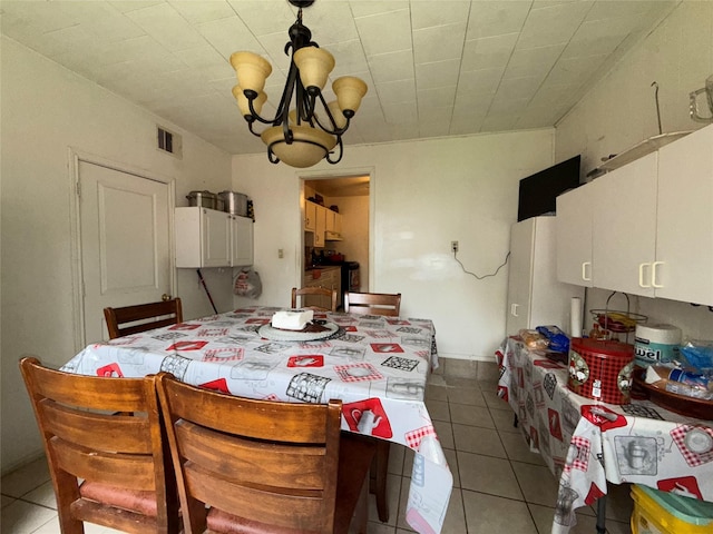 dining area with light tile patterned flooring and a chandelier