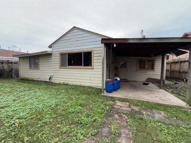 back of house with a carport and a yard