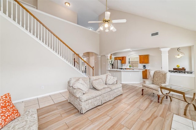 living room with decorative columns, high vaulted ceiling, ceiling fan, and sink