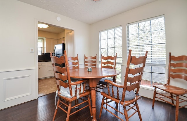 dining area featuring dark hardwood / wood-style floors and a textured ceiling