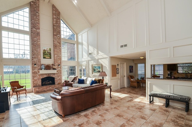 living room with beamed ceiling, a brick fireplace, and high vaulted ceiling