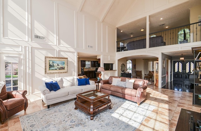 living room featuring plenty of natural light, high vaulted ceiling, and light tile patterned floors