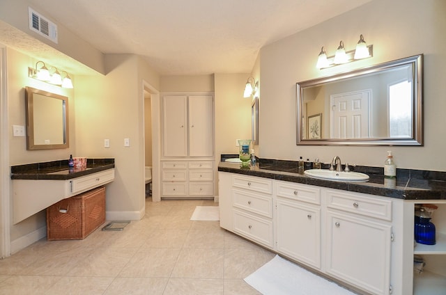 bathroom with tile patterned flooring, vanity, and toilet