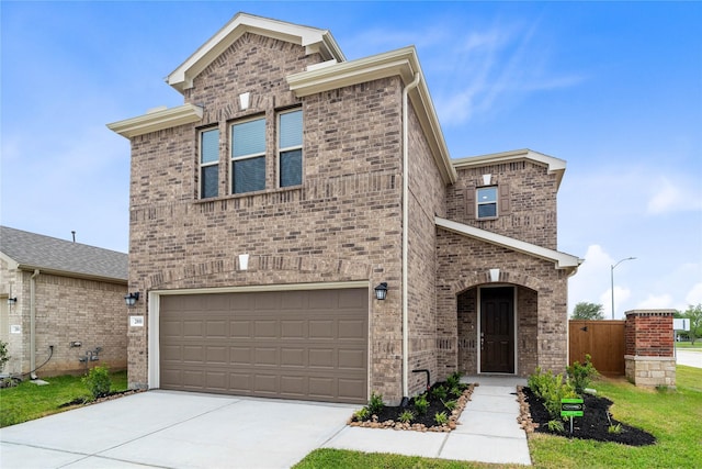 traditional-style home with brick siding, driveway, fence, and a garage
