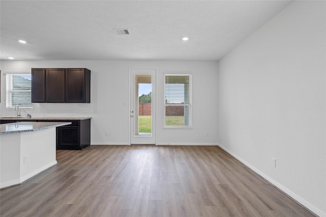 kitchen with recessed lighting, light wood-style floors, visible vents, and a sink
