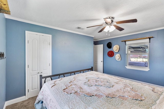 bedroom with carpet, ceiling fan, crown molding, and a closet