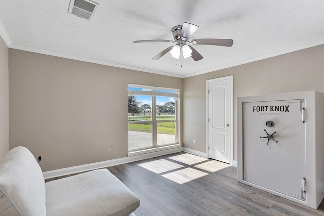 unfurnished room featuring hardwood / wood-style floors, ceiling fan, crown molding, and a textured ceiling