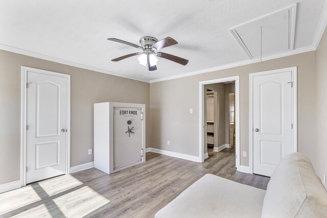 bedroom with ceiling fan, light hardwood / wood-style floors, ornamental molding, and a textured ceiling