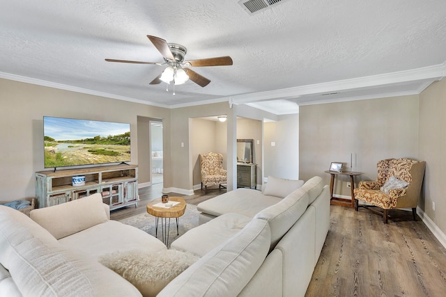 living room with crown molding, hardwood / wood-style floors, ceiling fan, and a textured ceiling