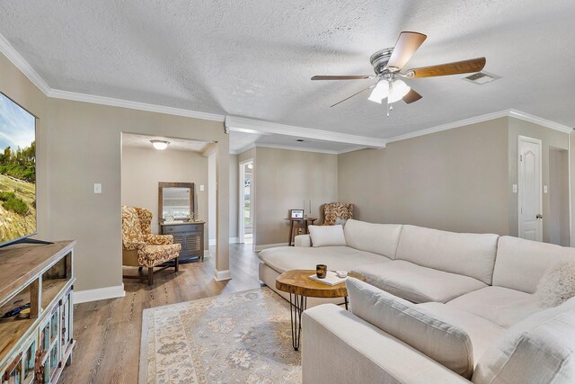 living room with ceiling fan, light hardwood / wood-style floors, ornamental molding, and a textured ceiling