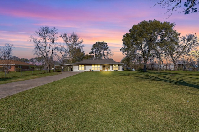 ranch-style home featuring a yard and a carport