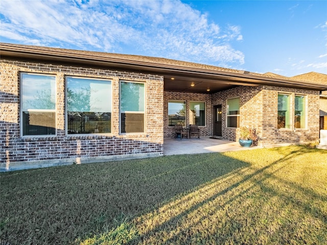 back of property featuring a yard and a patio