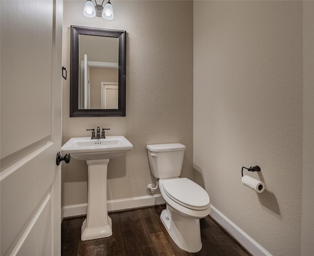 bathroom featuring toilet, hardwood / wood-style floors, and sink