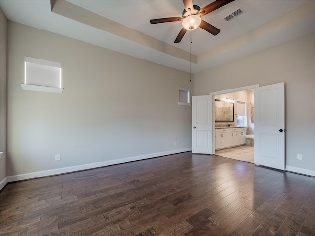 spare room featuring ceiling fan, wood-type flooring, and a tray ceiling