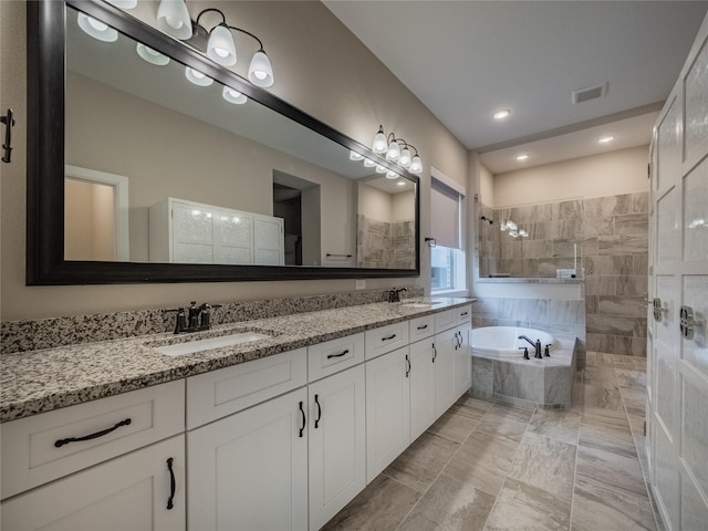 bathroom with vanity and shower with separate bathtub